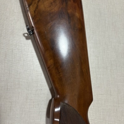 Parte traseira de uma arma de madeira castanha polida com textura entalhada