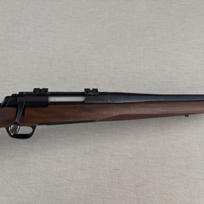Rifle de caça com coronha em madeira castanha e cano metálico preto