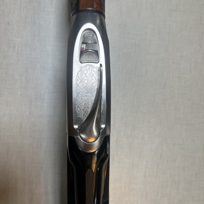 Espingarda com cabo em madeira e detalhes metálicos prateados decorados