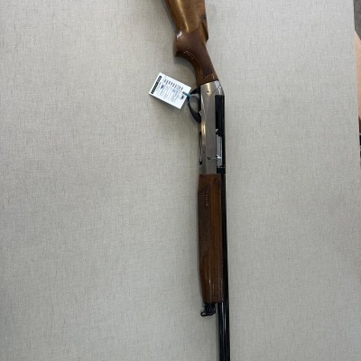 Espingarda com madeira castanha e metal prateado e preto sobre fundo cinza