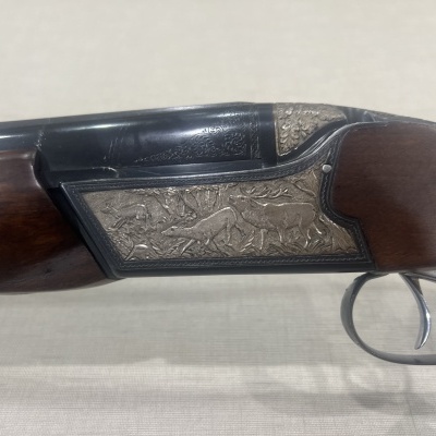 Espingarda de caça com madeira escura e gravação metálica detalhada