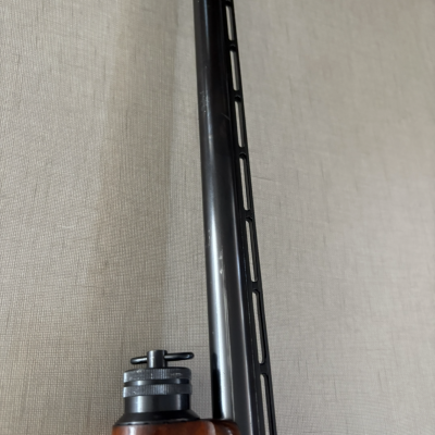 Cano de arma de fogo preto com ventilação e coronha de madeira