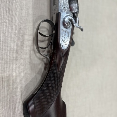 Espingarda de canos duplos com madeira escura e metal gravado