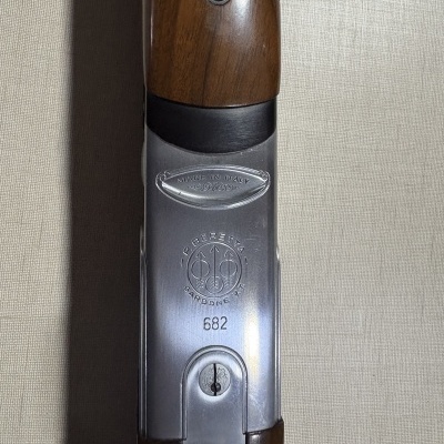 Parte central de uma arma de fogo de madeira e metal com gravações visíveis