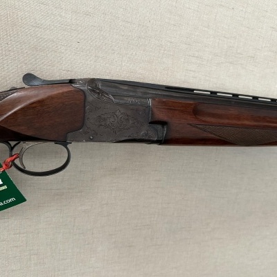 Rifle de caça de cano duplo com acabamentos em madeira e metal cinzento, etiqueta verde Palomucha