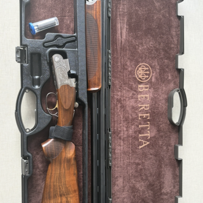 Espingarda Beretta desmontada num estojo preto aberto com veludo castanho interior e texto BERETTA