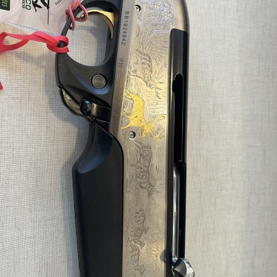 Espingarda com madeira castanha e metal prateado gravado com desenhos de animais