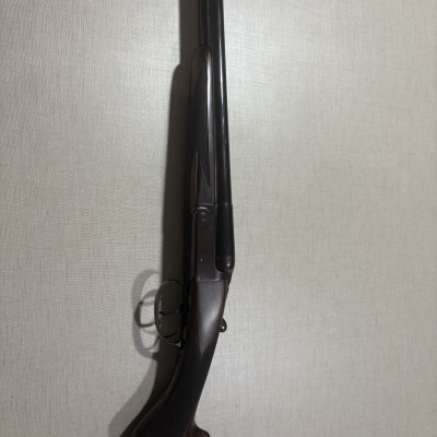 Espingarda canos duplos com coronha madeira castanha e detalhes metálicos