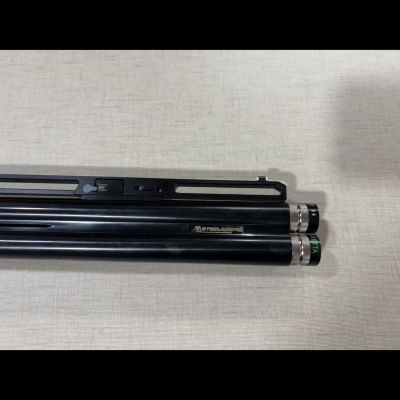 Objeto preto metalizado cilíndrico com tampas prateadas e marca 'STEELBONE'