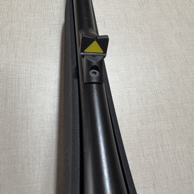cano preto com suporte e peça triangular amarela em superfície bege