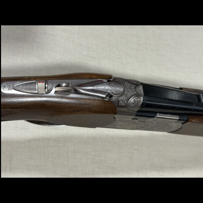 Espingarda de canos duplos com acabamento em madeira e metal gravado
