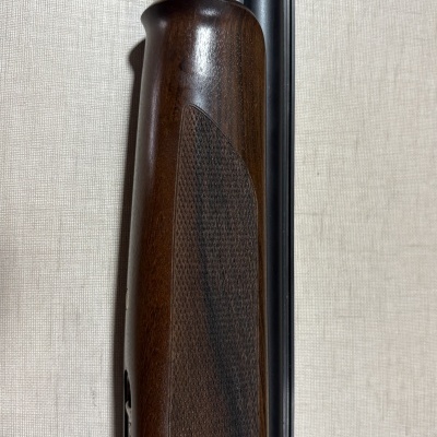 Arma de fogo de madeira escura e metal preto com tubo duplo