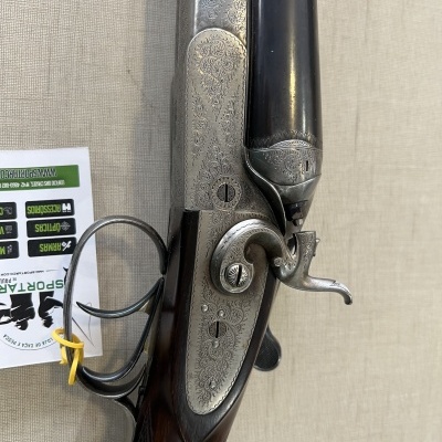 Espingarda de canos paralelos em madeira e metal gravado com etiqueta ao lado