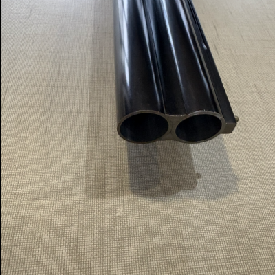 Cano duplo de arma de fogo sobre superfície texturizada bege