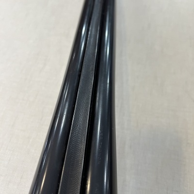 Pau cilíndrico preto com acabamento brilhante em fundo claro