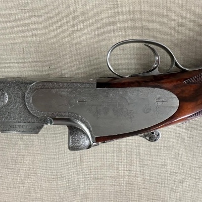 Espingarda com cabo de madeira e gravações metálicas decorativas