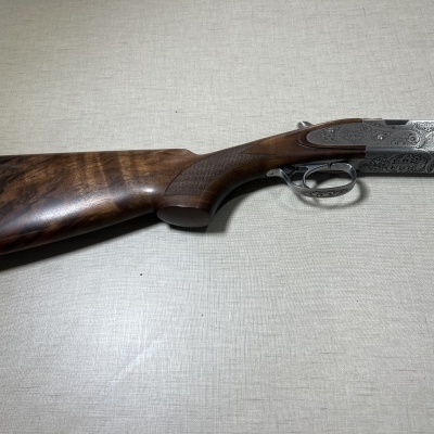 Espingarda de madeira com metal gravado em padrão ornamental