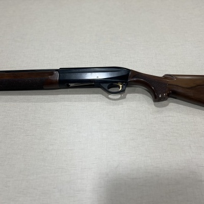 Espingarda de caça com madeira castanha e corpo metálico preto