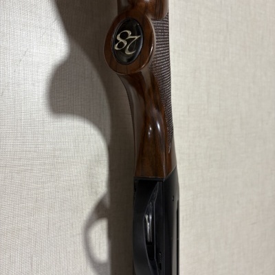 Coronha de madeira escura com número 28 em placa preta e parte metálica preta com gravação XA00110