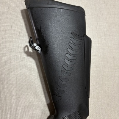 Stock de arma de fogo preto com textura antiderrapante e botão RELEASE.