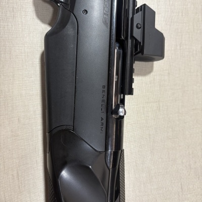 Parte superior de arma de fogo preta com mira óptica e texto BENELLI ARMI Argo