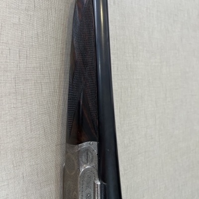 Espingarda de canos paralelos com madeira texturizada e detalhes metálicos