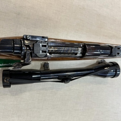 Espingarda com coronha em madeira e partes metálicas pretas com luneta telescópica