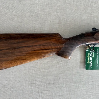 Espingarda com coronha de madeira e etiqueta verde ao gatilho
