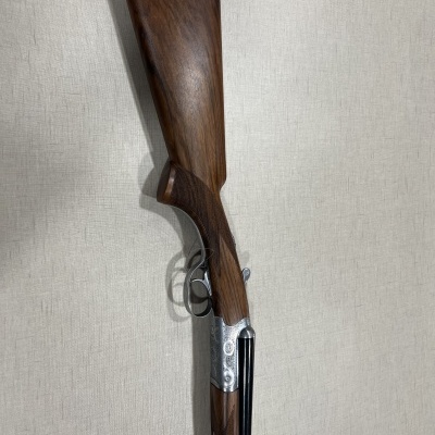 Espingarda de caça com madeira e metal em fundo cinzento