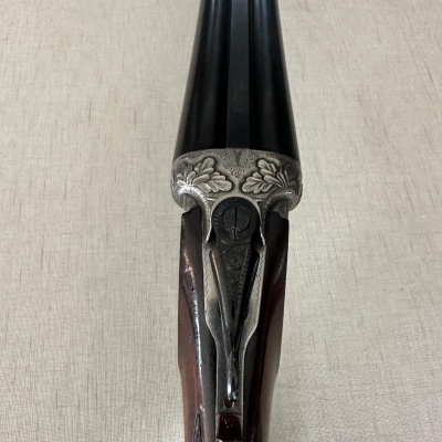 Espingarda de canos duplos com detalhes em metal prateado e madeira castanha