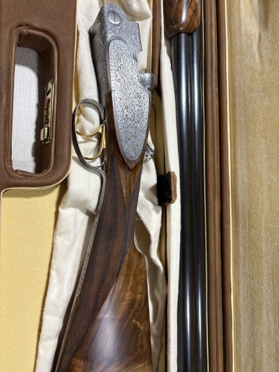 Espingarda de madeira e metal decorada numa caixa bege