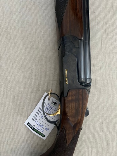 Espingarda de canos sobrepostos com acabamento em madeira castanha e detalhes metálicos pretos