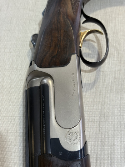 Caça com acabamento em madeira escura e detalhes metálicos com inscrições Perazzi MX8 e BERETTA BERG. - MADE IN ITALY