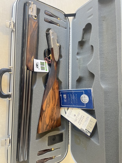 Estojo cinzento com espingarda desmontada, munições Fiocchi LFZ e documentos