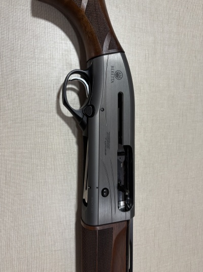 Espingarda semiautomática Beretta em madeira e metal cinza escuro com gatilho prateado