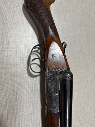 Espingarda de caça com coronha em madeira e cano duplo em metal gravado
