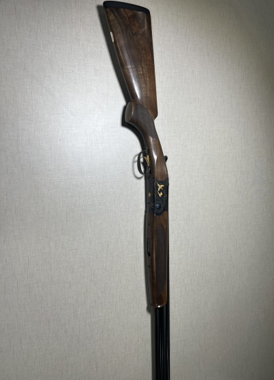Espingarda de cano duplo com madeira castanha e detalhes dourados