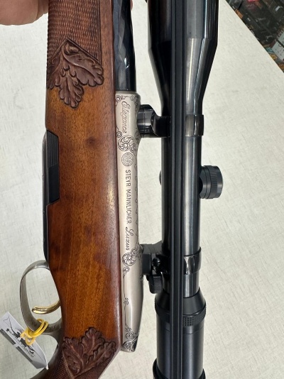 Rifle de madeira e metal com entalhes decorativos e visor óptico