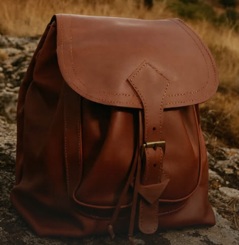 Mochila de couro castanho com fivela metálica na natureza