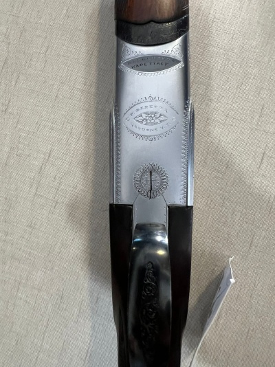 Parte superior de espingarda com metal gravado e punho em madeira escura