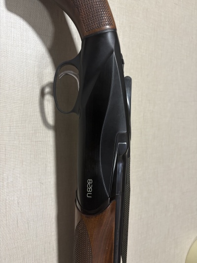 Espingarda com madeira castanha, corpo metálico preto e texto branco n828