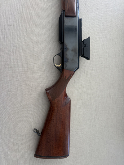 Arma de fogo com coronha de madeira castanha e corpo metálico preto com marcação BROWNING BAR II