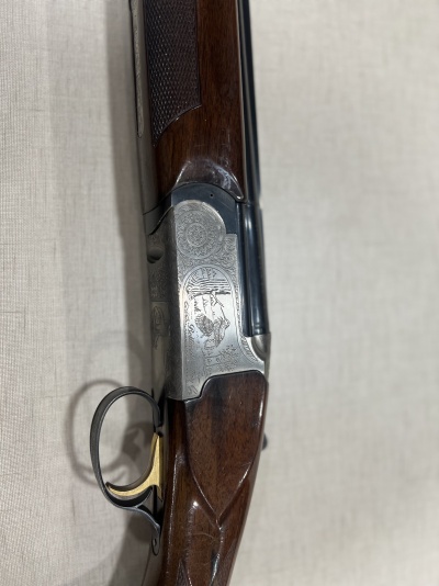 Espingarda de canos emparelhados com acabamento em madeira e metal gravado