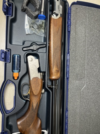 Espingarda desmontada em estojo azul com acessórios