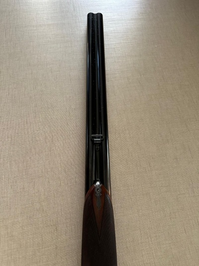 Espingarda de canos duplos paralelos em metal preto com empunhadura em madeira escura