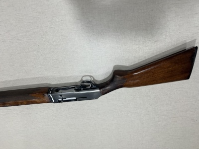 Espingarda com coronha e punho em madeira e corpo metálico preto