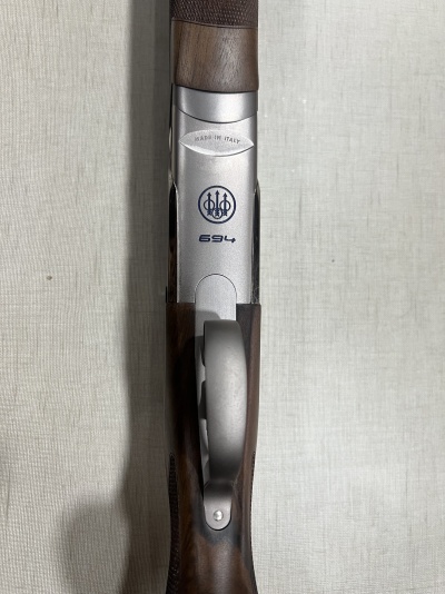 Espingarda de madeira e metal com inscrições e símbolo da marca Beretta