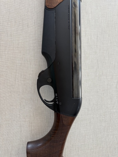 Parte de arma de fogo com cabo de madeira castanha e corpo preto fosco com texto URBINO MADE IN ITALY