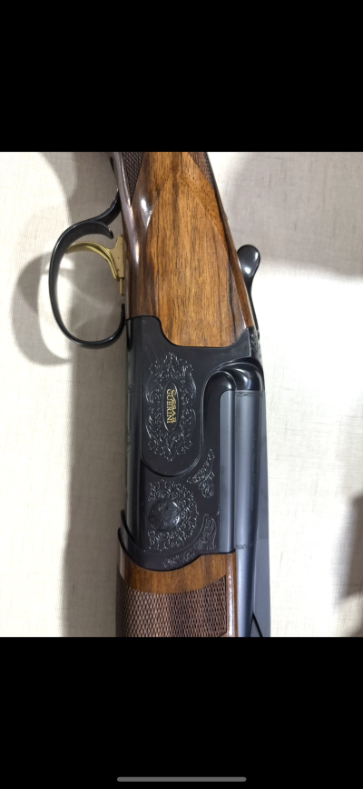 Espingarda de cano duplo com madeira e detalhes gravados em metal negro
