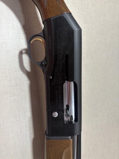 Espingarda de caça com cabo em madeira e corpo metálico preto